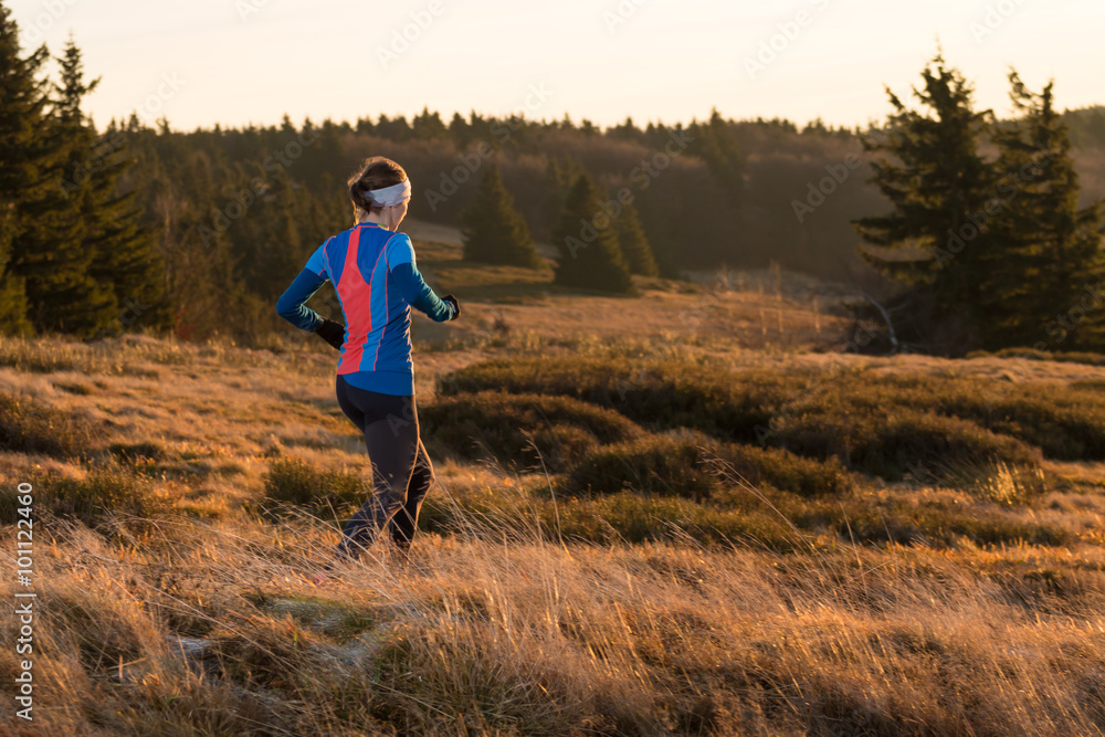 young woman running for fitness on the trail in the morning in spring mountains