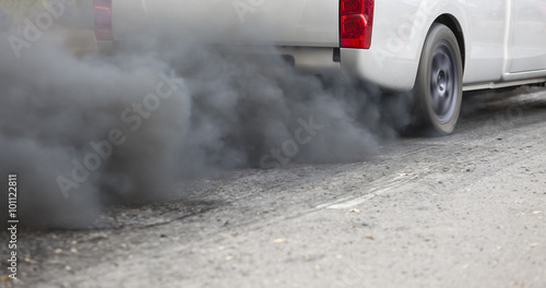 Air pollution from vehicle exhaust pipe on road photo