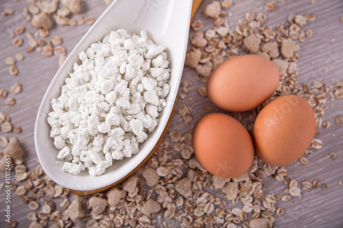 Cottage cheese, eggs on the background of scattered muesli.