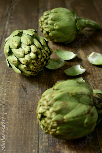 raw artichokes on a wooden surface