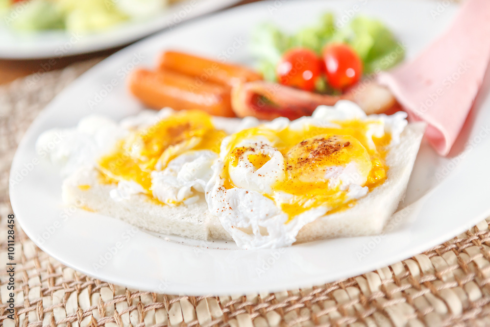 bread with scrambled eggs in white plate.