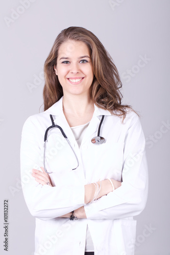 Female doctor standing and smiling with her arms crossed 