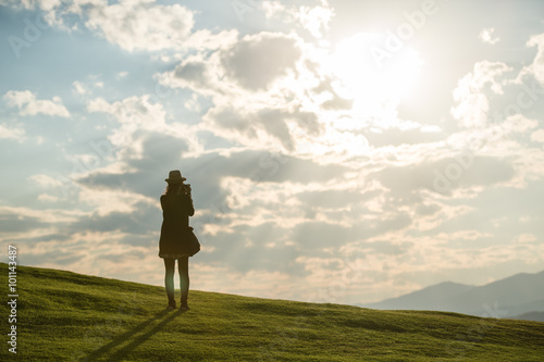 Girl taking photo on sunset