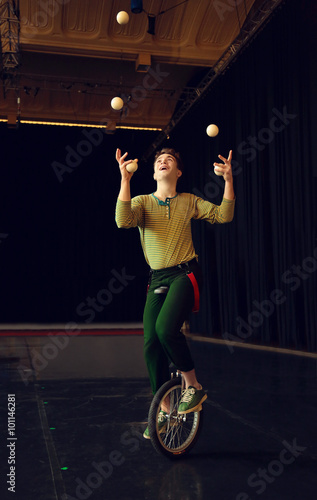 Boy juggling and riding unicycle photo