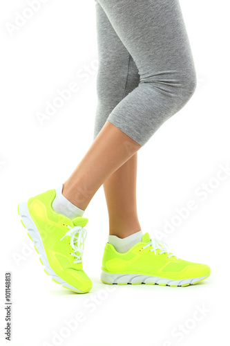 Sneakers on women legs on a white background