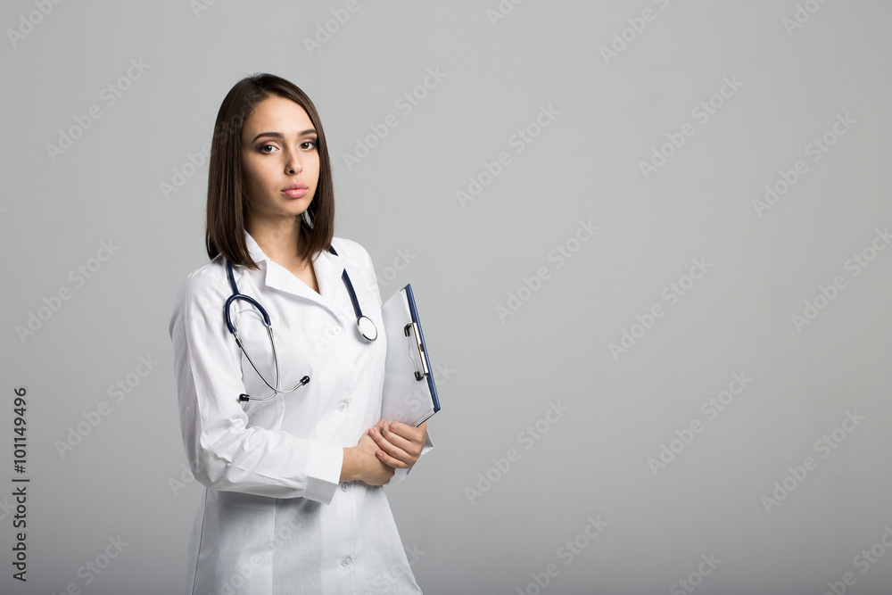Beautiful smiling doctor woman on a gray background Beautiful smiling doctor woman on a gray background