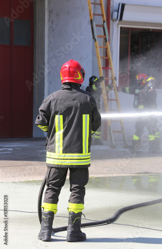 Firefighter sprays water with the spear fighting during the exer