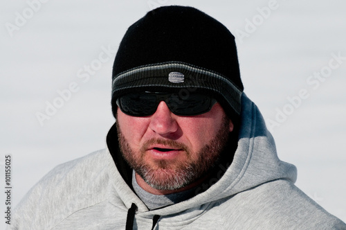 Middle aged man with beard and tobaggan in snow. photo