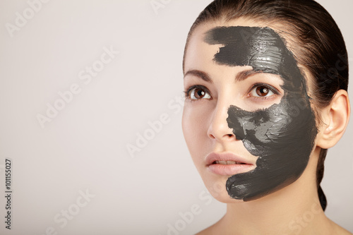 Foto Beautiful girl with clay mask on her face