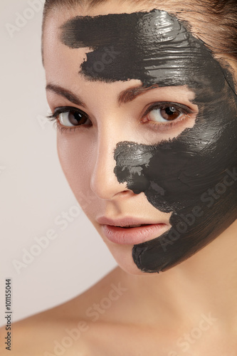 Beautiful girl with clay mask on her face