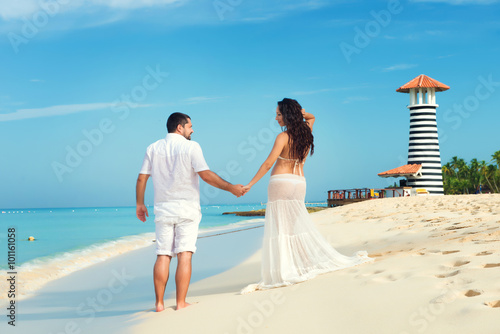 Beautiful young pregnant couple on the Caribbean coast. Happy pregnancy