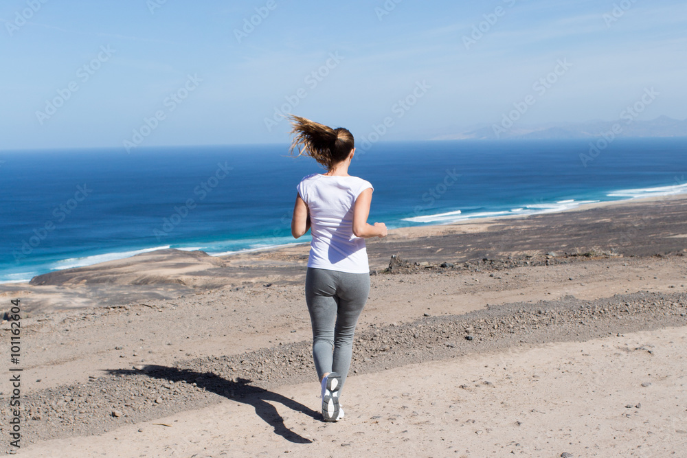 Attraktive Frau joggt am Strand von hinten