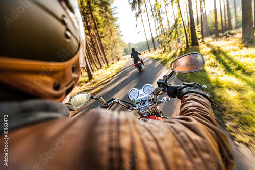 Fototapeta Człowiek siedzieć na motocyklu na leśnej drodze.