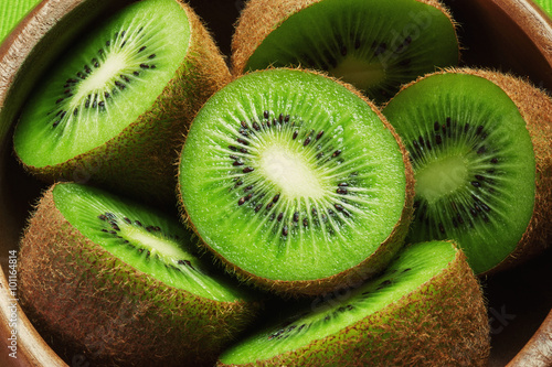 Fototapet Juicy ripe kiwi fruit in wooden bowl