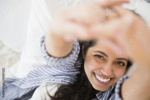 Close up portrait of smiling Asian woman laying in bed
