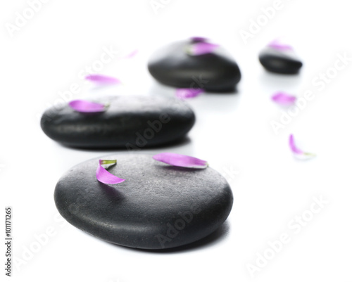 Hot spa stones with flower petals, isolated on white