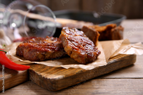 Roasted beef fillet and vegetables on cutting board, on wooden background