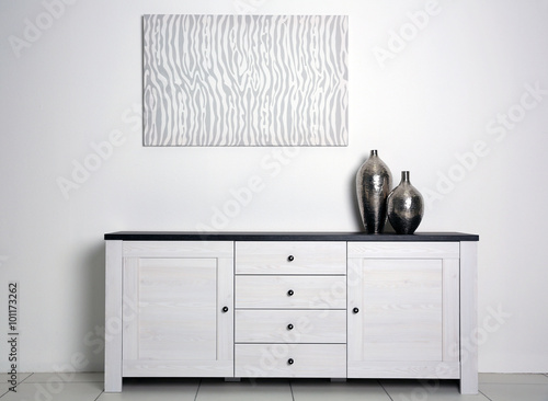 Abstract picture with vases and commode on a white wall background photo