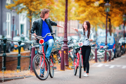 Photography Young happy caucasian couple on bikes in Amsterdam