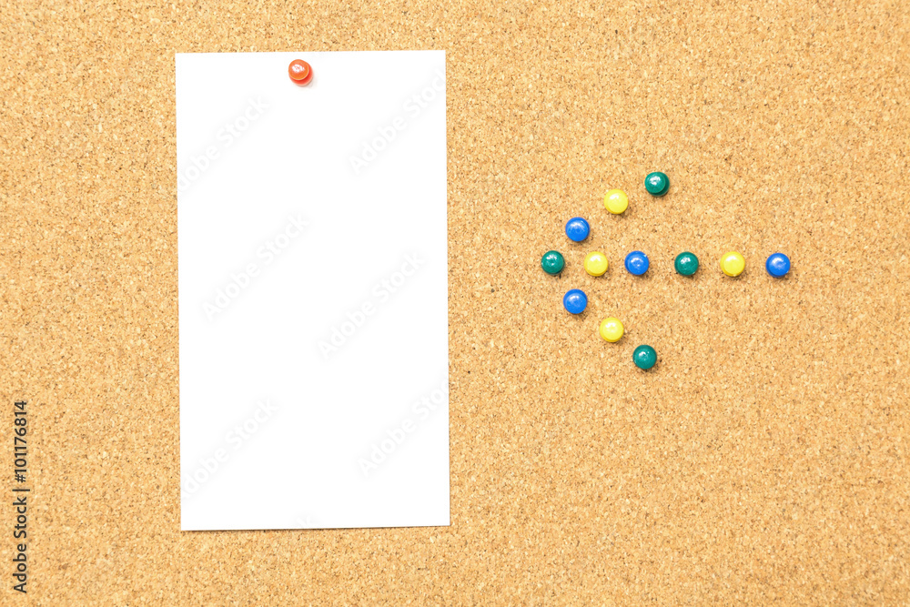 white blank paper on cork board with arrow sign white blank paper on cork board with arrow sign