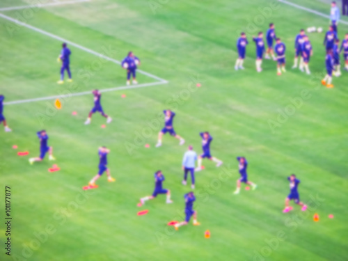 soccer player warm up in the green grass before the game start - blurred.
