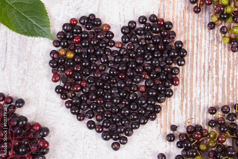 Heart of elderberry on old wooden background, symbol of love Heart of elderberry on old wooden background, symbol of love