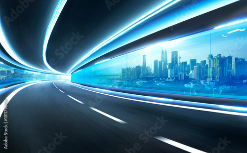 Abstract blurred speed motion road in glass tunnel over the city