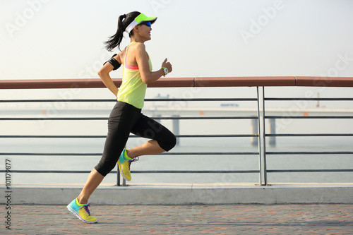 Fotografie young fitness woman runner running on seaside bridge