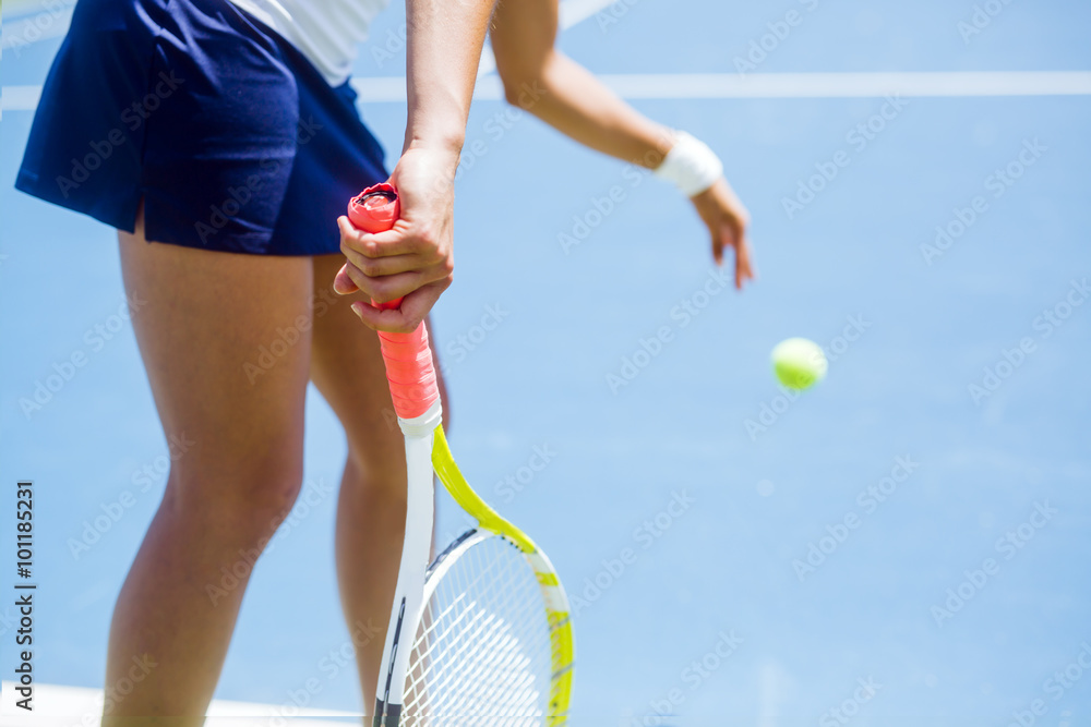 Beautiful female tennis player serving