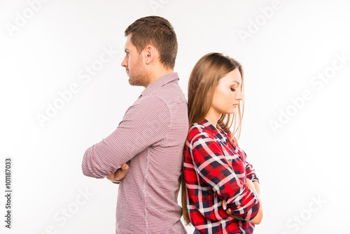 Young couple standing back to back ignoring each other