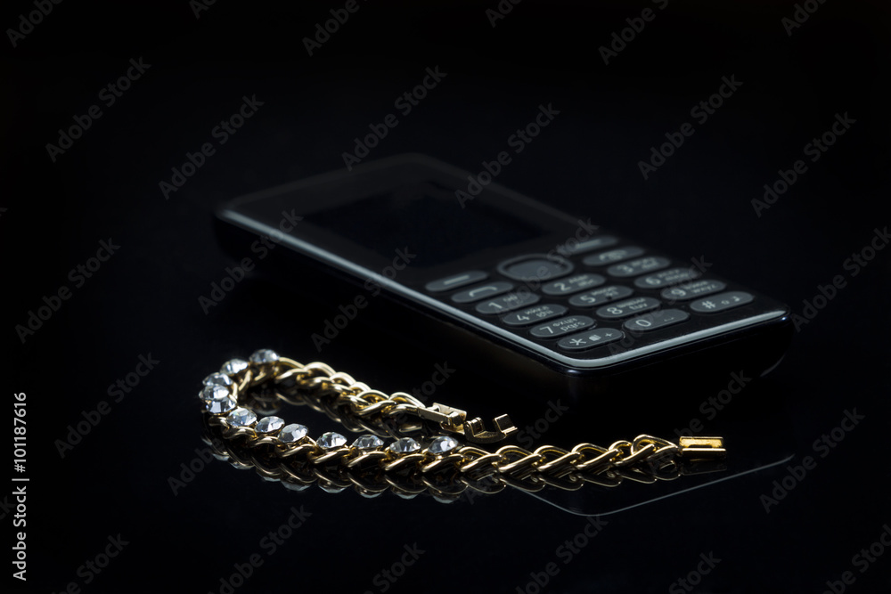Jewelery with a cell phone on gradient dark background Jewelery with a cell phone on gradient dark background
