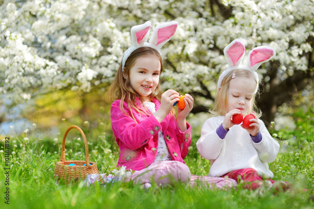 Two adorable little sisters playing with Easter eggs on Easter day