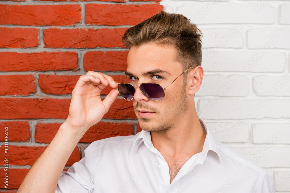 Smart handsome young man holding his glasses Smart handsome young man holding his glasses
