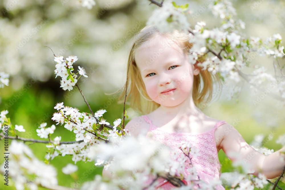 Adorable little girl in blooming cherry garden Adorable little girl in blooming cherry garden