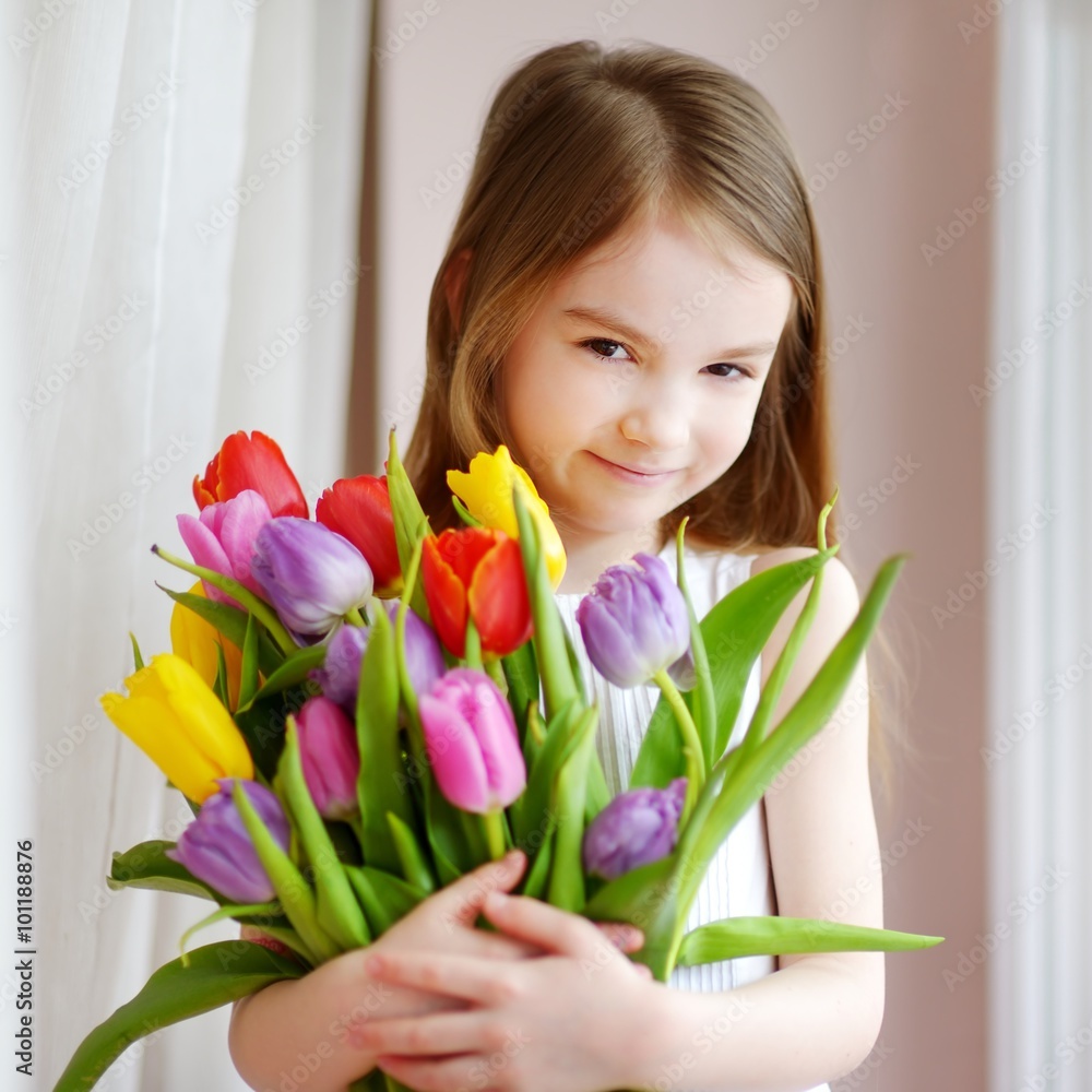 Adorable smiling little girl with tulips