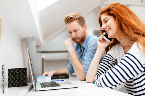 Beautiful ginger woman working in office with colleague