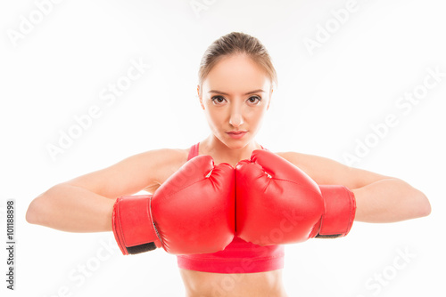 Portrait of young sportswoman in red boxing gloves