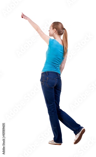 back view of walking woman in jeans and shirt pointing