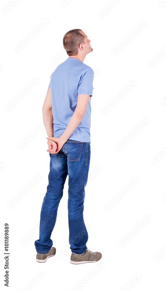 Back view of young man in t-shirt and jeans looking. Back view of young man in t-shirt and jeans looking.