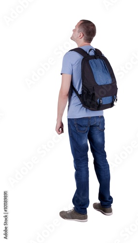 Back view of man with  backpack looking up.