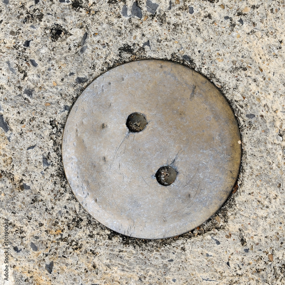 Manhole cover on street, top view.