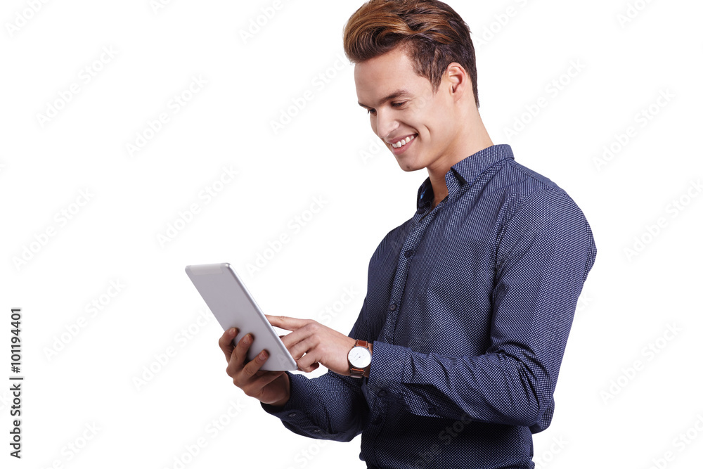 Smiling young man using tablet computer against a white background Smiling young man using tablet computer against a white background