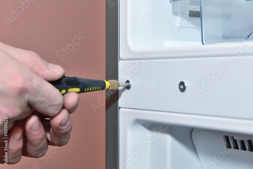 Worker twists the screw with a screwdriver closeup