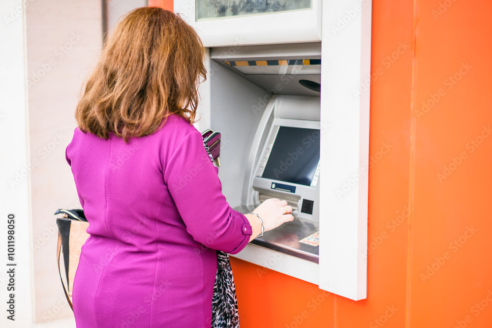 Back view of woman using atm Back view of woman using atm