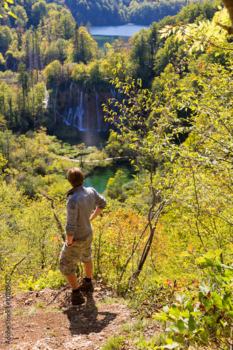 Beautiful viewpoint in Plitvice national park in Croatia in autumn with a hiker looking out over the park © dennisvdwater