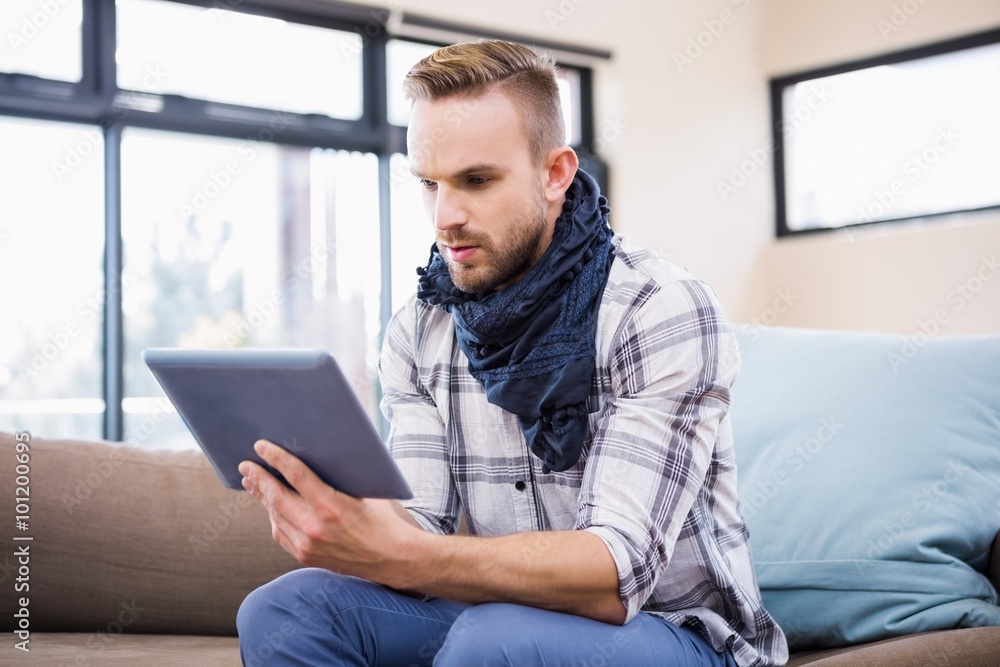 Handsome man using tablet on the couch Handsome man using tablet on the couch