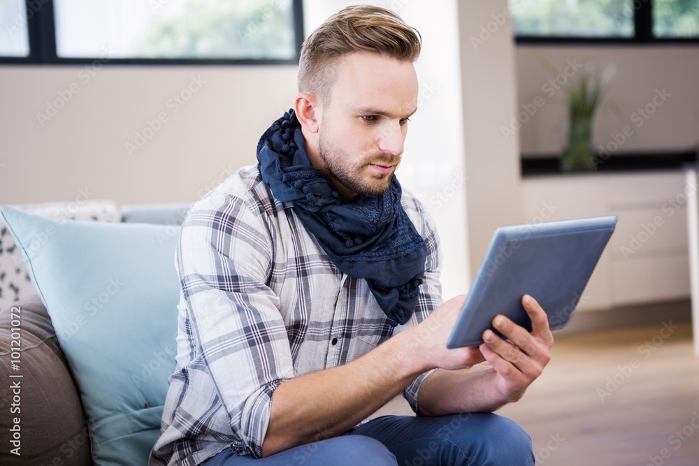 Handsome man using tablet on the couch Handsome man using tablet on the couch
