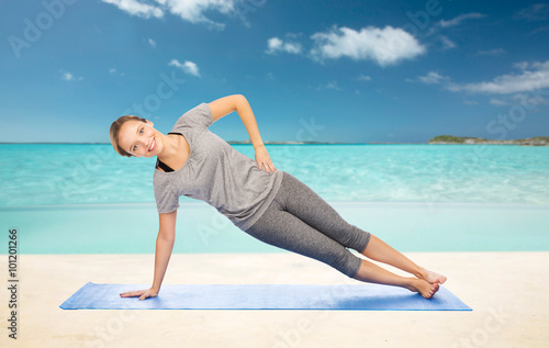 woman making yoga in side plank pose on mat