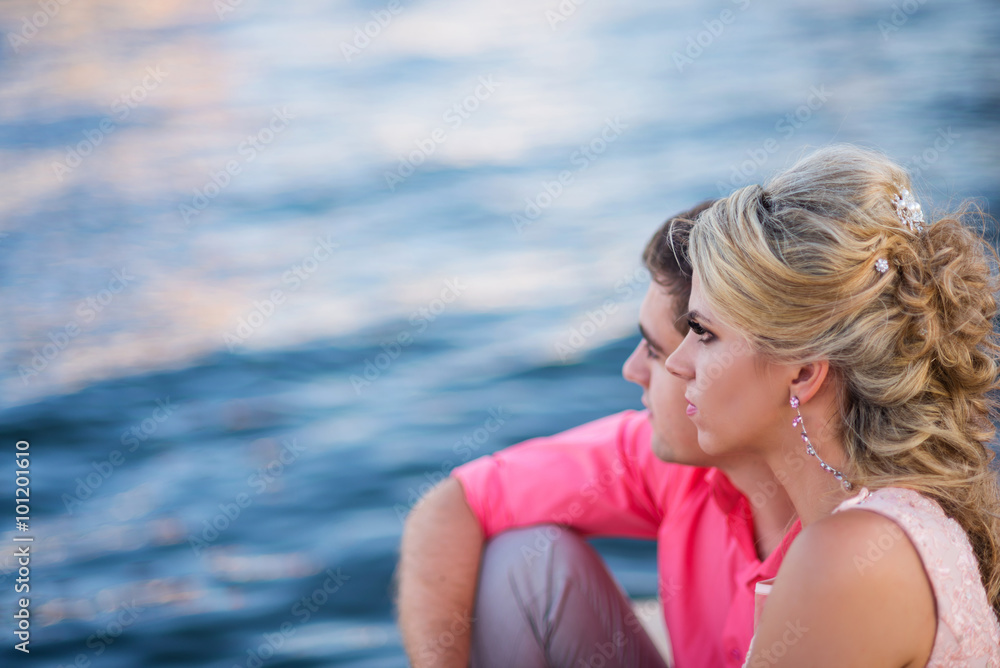 Young beautiful couple is looking at water. Back view Young beautiful couple is looking at water. Back view