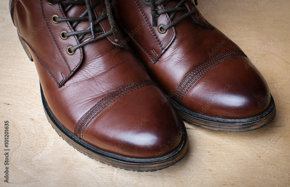 brown men's boots on wooden background